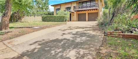 A two-story house with a garage, a driveway, and a well-maintained lawn.