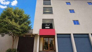Un edificio moderno con escaparate, un árbol y una puerta de garaje cerrada.