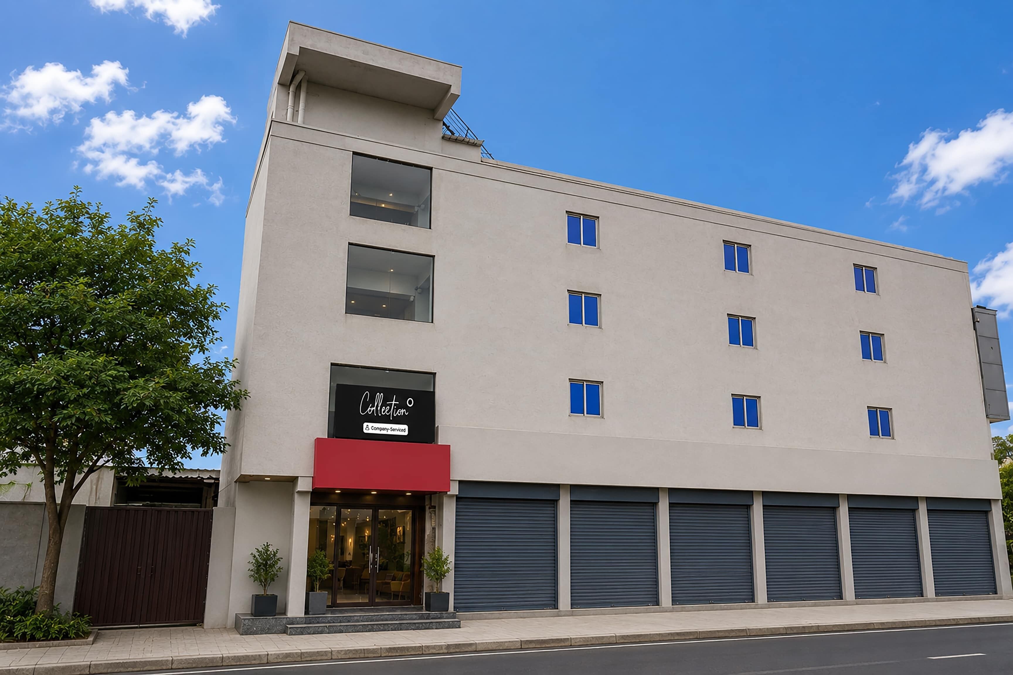 A modern building with a flat facade, multiple windows, and a visible storefront with a sign.