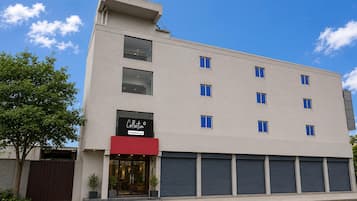 A modern building with a flat facade, multiple windows, and a visible storefront with a sign.