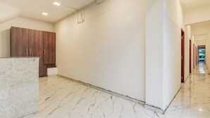 Un pasillo con suelo de mármol, armarios de madera y un diseño moderno y elegante.