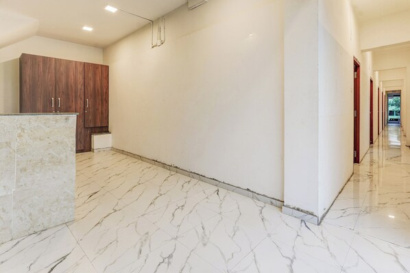 Un pasillo con suelo de mármol, armarios de madera y un diseño moderno y elegante.