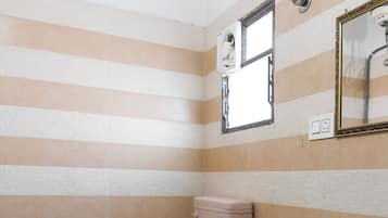 A small bathroom with a toilet, sink, and shower.