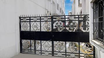 A gated entrance with decorative metalwork and a clear view of the street beyond.