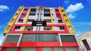 A multi-story building with a prominent 'Collection' sign, large windows, and a modern architectural design. - Collection O Tarapith Railway Junction (Tarapith)