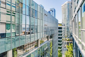Un moderno edificio de gran altura con fachadas de vidrio reflectante y varios balcones.