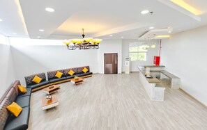 A spacious living area with a sectional sofa, a coffee table, and a modern chandelier.
