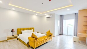 Una habitación de hotel moderna con cama, mesita de noche y un banco integrado.