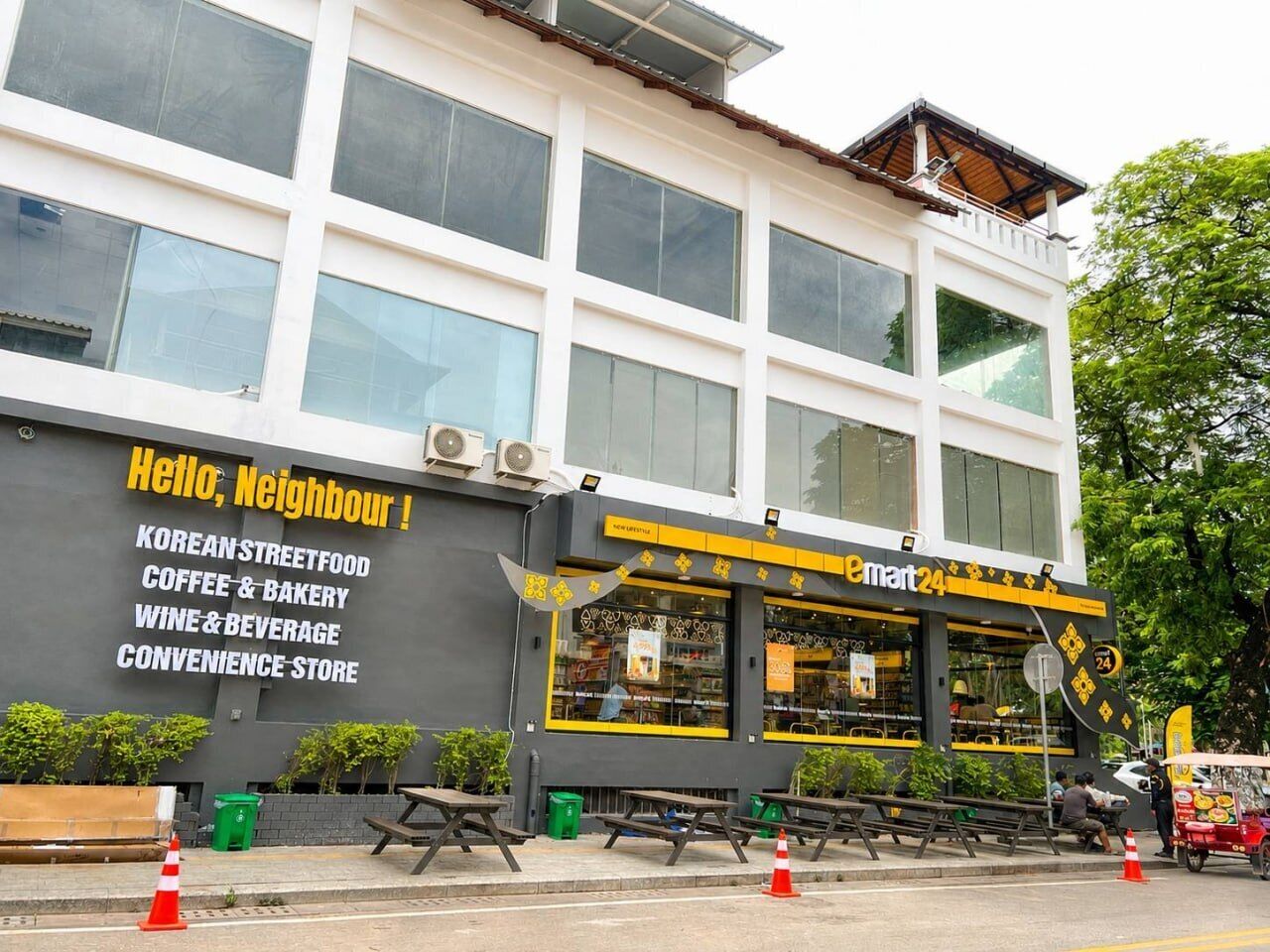 A building with a sign advertising Korean street food, coffee & bakery, wine & beverage, and a convenience store.
