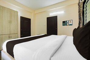 A hotel room with a bed, wardrobe, and a wall-mounted picture. - Collection O Tirupati Railway (Tirupati)