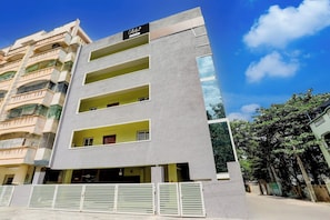 A multi-story building with a modern facade, a visible company sign, and a gated entrance. - Collection O Tirupati Railway (Tirupati)