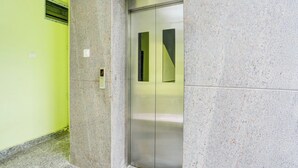 An elevator with a digital display, a metallic door, and a granite wall. - Collection O Tirupati Railway (Tirupati)