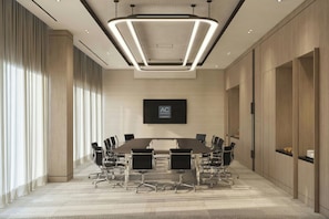 A conference room with a long table, chairs, and a large screen. - AC Hotels by Marriott Airport City Belgrade (Belgrade)