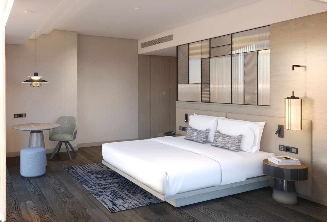 A modern hotel room with a large bed, a round table, a chair, and a wall-mounted mirror.