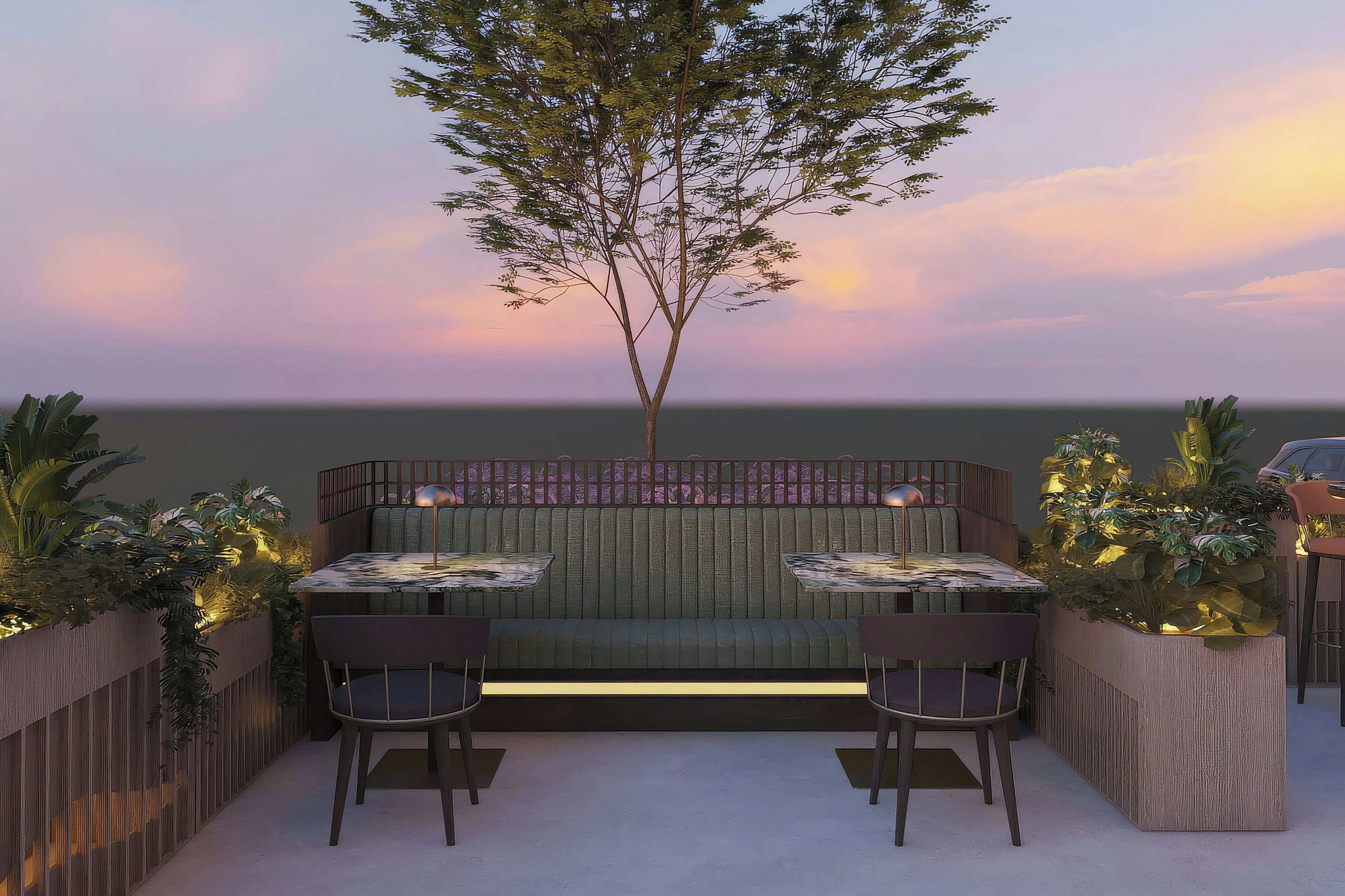 An outdoor seating area with two tables and chairs, a wooden fence, and a tree.