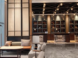 A modern lobby with a seating area, a reception desk, and a display of decorative items.
