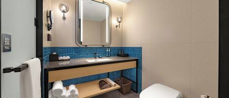 Un baño moderno con lavamanos, espejo, toallero y retrete.