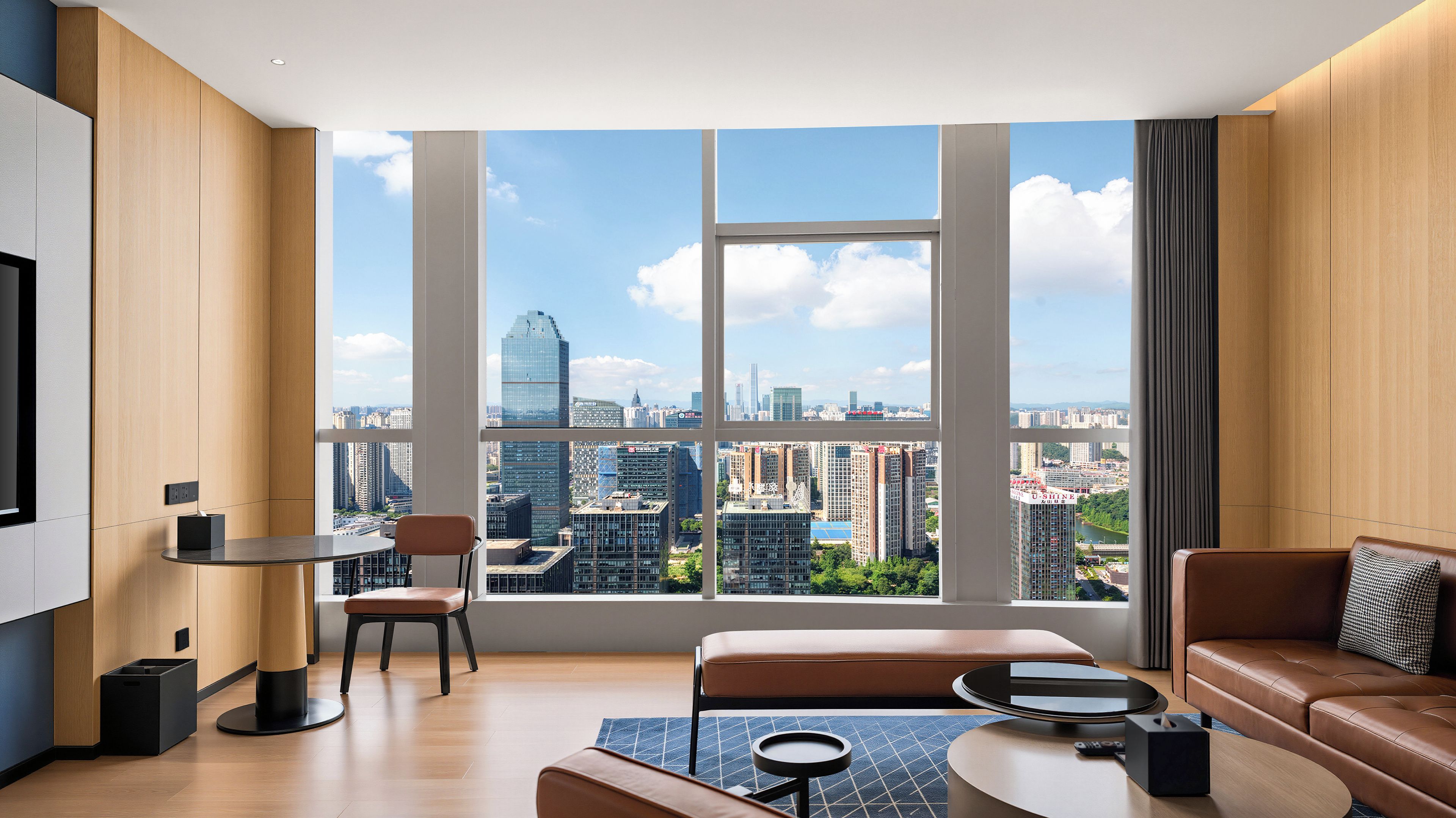A modern living room with a large window, a sofa, a coffee table, and a chair.