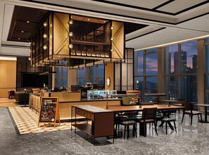 A modern interior with a bar area, seating, and large windows offering city views.