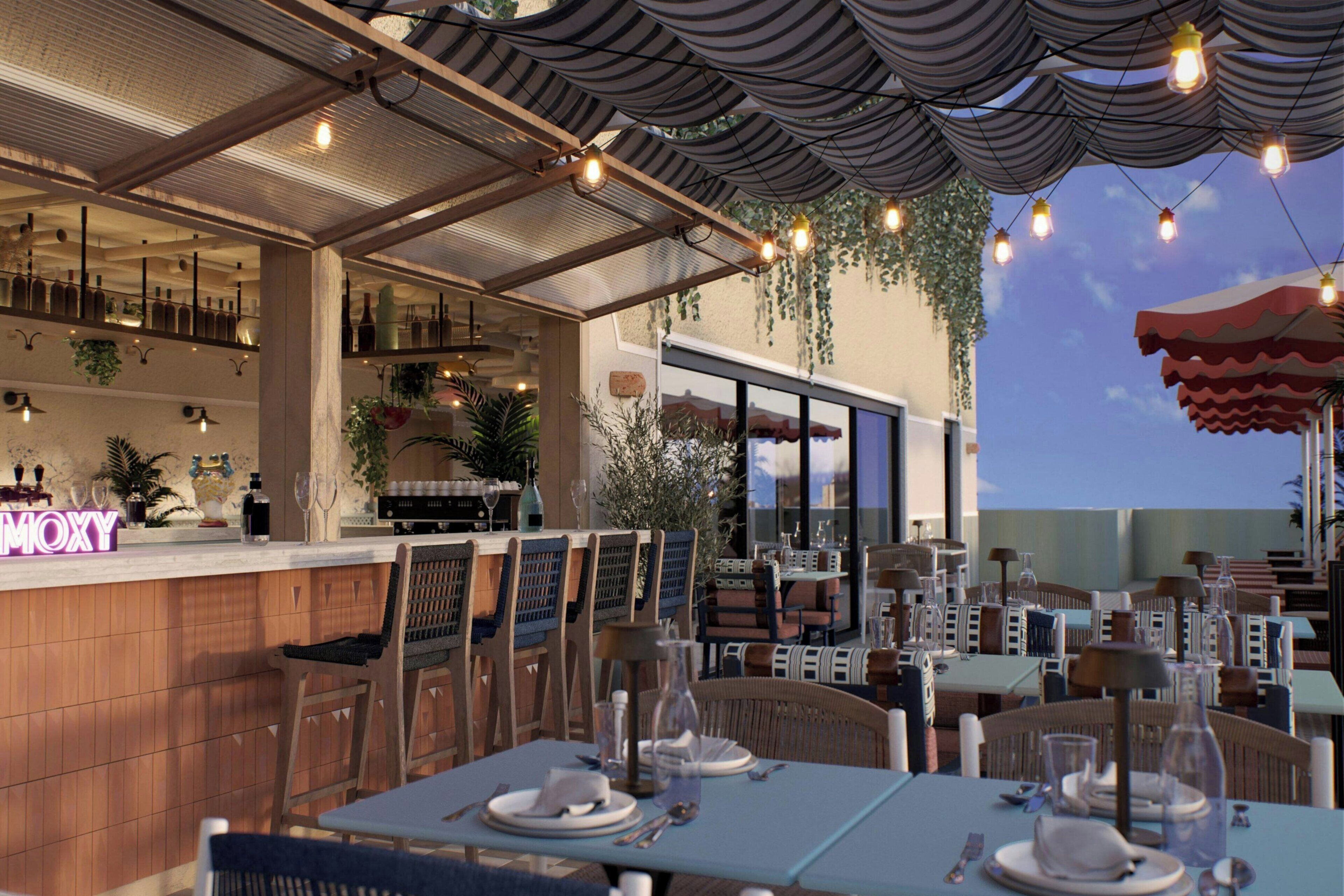 Un área de comedor al aire libre con mesas y sillas, un bar con botellas, y plantas colgantes.