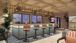 A bar area with a counter, bar stools, and a view through the windows. - Moxy St. Julian's Malta (St. Julian's)