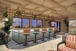 A bar area with a counter, bar stools, and a view through the windows. - Moxy St. Julian's Malta (St. Julian's)