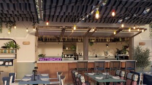 A restaurant interior with checkered flooring, tables with chairs, a bar area, and hanging lights. - Moxy St. Julian's Malta (St. Julian's)