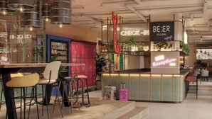 A bar area with stools, a neon sign, and a reception desk. - Moxy St. Julian's Malta (St. Julian's)