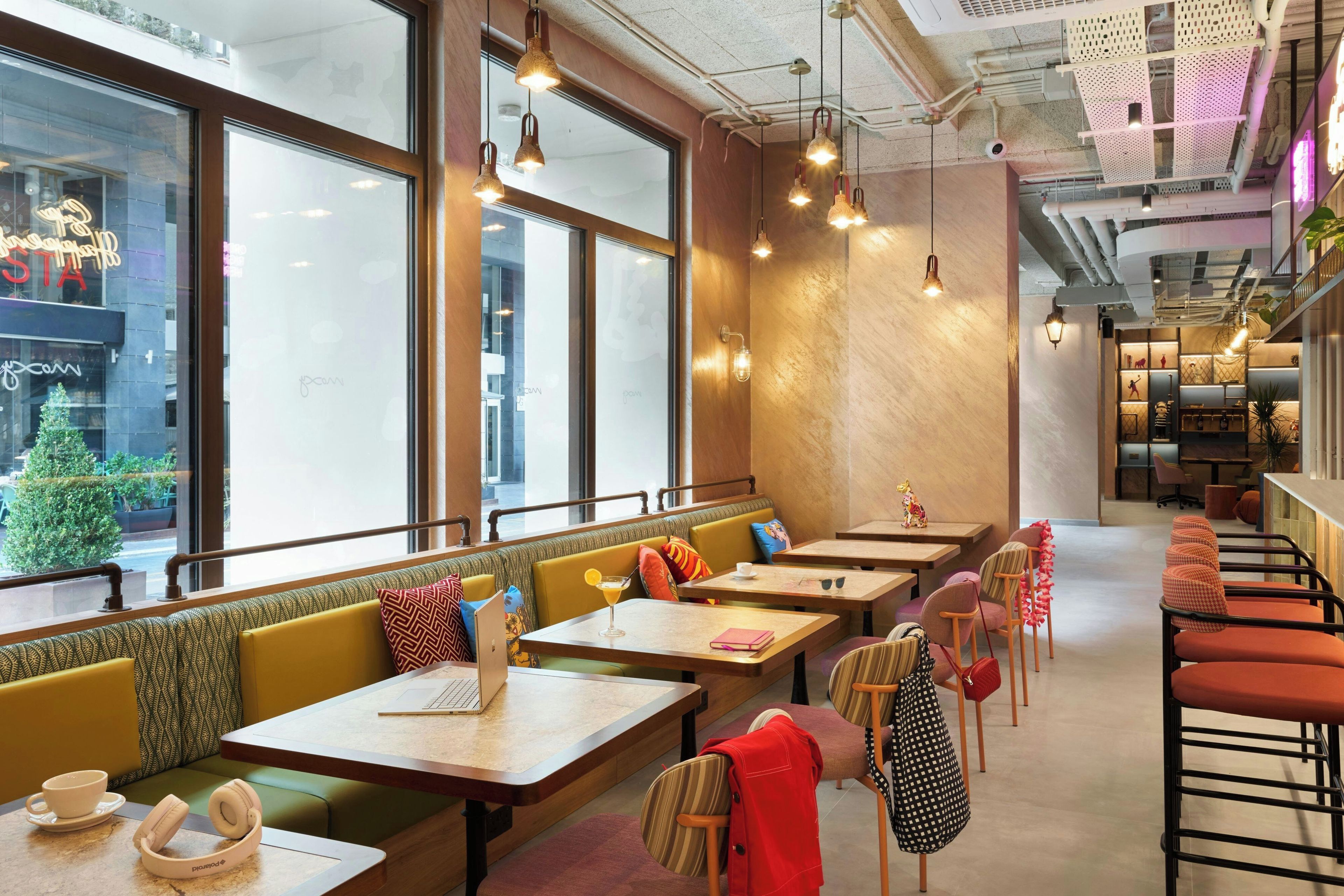 A restaurant interior with booths, tables, and hanging lights.