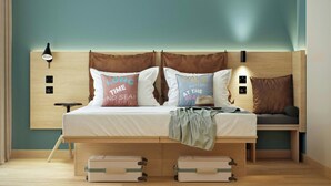 A bed with two pillows, a bedside lamp, and a headboard with wall-mounted lights. - Moxy St. Julian's Malta (St. Julian's)