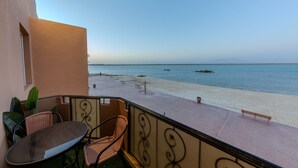 Un balcon avec vue sur une plage et la mer.