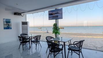 A modern indoor seating area with a view of the beach.