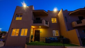 Un immeuble à plusieurs étages, doté d’une façade sobre, de balcons et d’une entrée fermée par un portail.