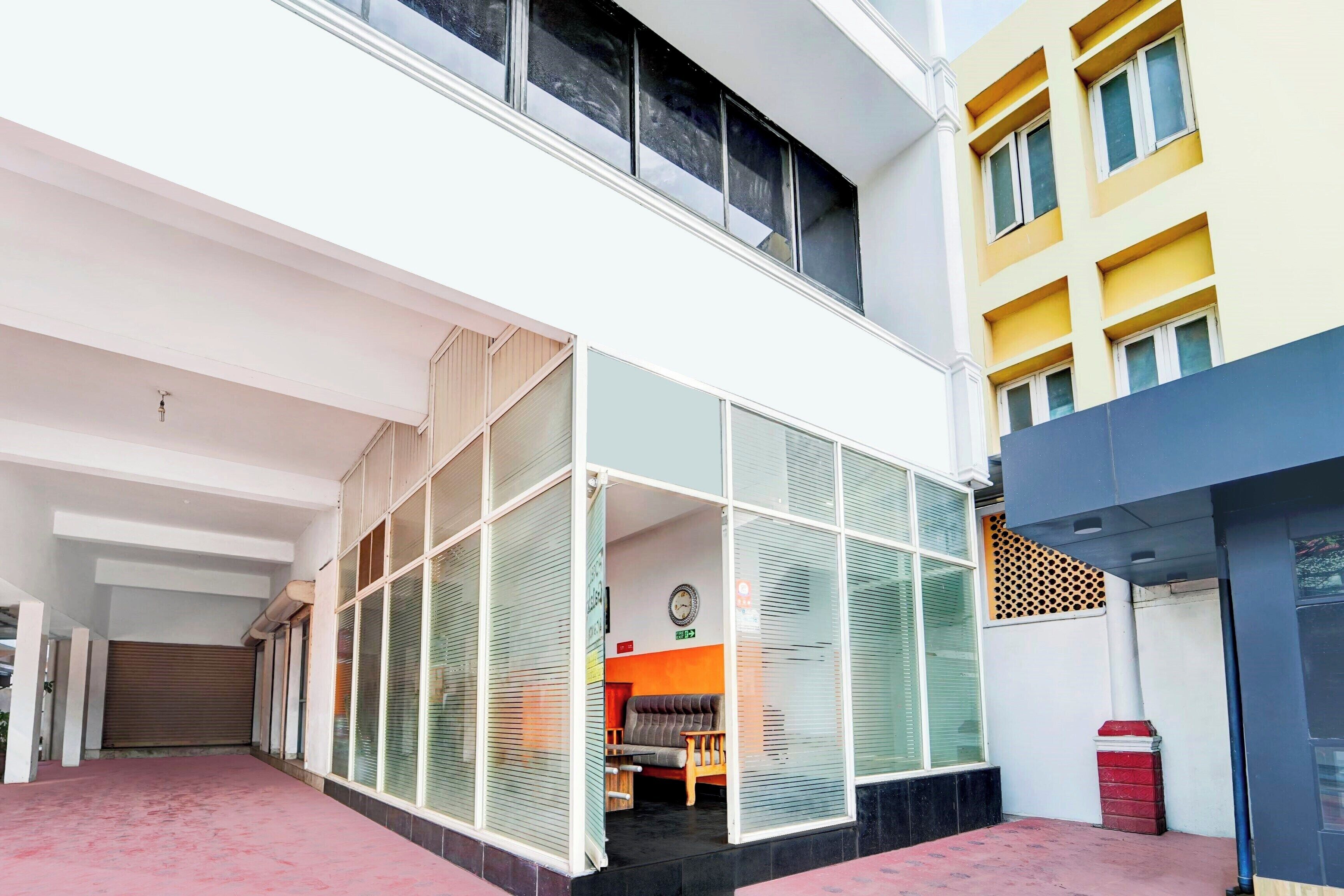 A building with a covered outdoor area, a visible entrance, and a staircase leading to an upper floor.