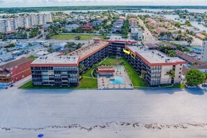 Un hotel con un patio central, varios pisos y una zona de piscina.