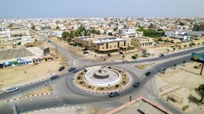 A cityscape with a roundabout, buildings, and a clear sky. - Hotel Aloe Emira Nouackchott (Nouakchott)