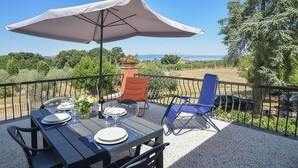 An outdoor patio with a table set for dining, a chair, and a large umbrella. - Gorgeous apartment in Viterbo with WiFi (Viterbo)
