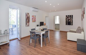 A modern living room with a dining area, a white sofa, and a TV on a stand. - Gorgeous apartment in Viterbo with WiFi (Viterbo)