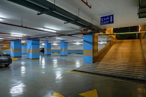 En parkeringsgarage med blå søjler, en bil og et udgangsskilt.