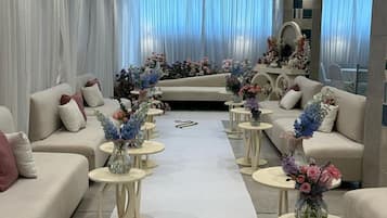 Un moderno vestíbulo de hotel con sofás, mesas redondas y arreglos florales.