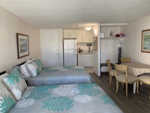 A compact room with a bed, a small kitchenette, and a dining area. -  Waikiki apartment, close to the beach, early check in available (Honolulu)