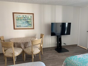A hotel room with a dining table, two chairs, a television, and a bed. -  Waikiki apartment, close to the beach, early check in available (Honolulu)