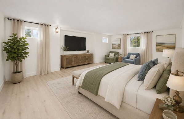 Un dormitorio con una cama, televisor, planta, ventana y un cuadro.