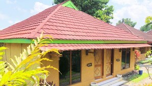 A two-story building with a red roof and a green trim. There are windows on the ground floor and a door with a sign above it. - Hotel Galuh and Water Park Prambanan  (Prambanan)