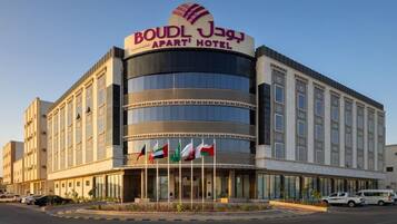 Un hotel con un letrero llamativo, varias banderas y una fachada moderna.
