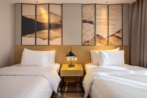 A hotel room with two beds, a nightstand with a lamp, and a wall with a large abstract painting. - Boudl Al Rawdha (Buraydah)