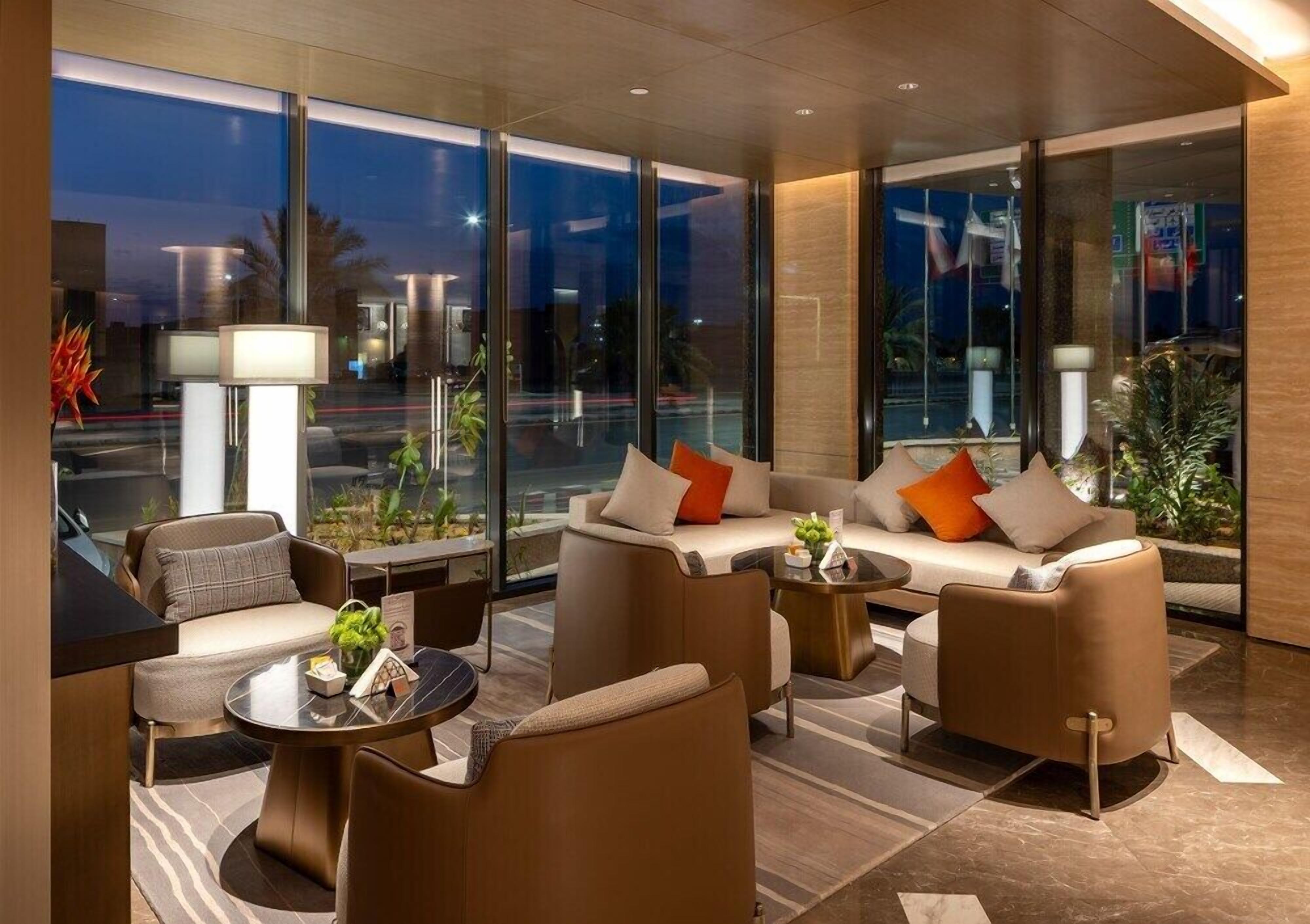 A modern hotel lobby with a sofa set, a coffee table, and a lamp.