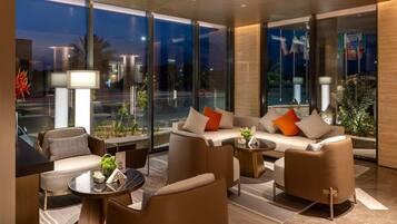 A modern hotel lobby with a sofa set, a coffee table, and a lamp.