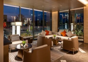 A modern hotel lobby with a sofa set, a coffee table, and a lamp.