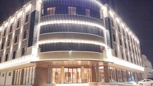 Un hotel con fachada curva, varios pisos y un letrero destacando que es un 'Apart Hotel'.